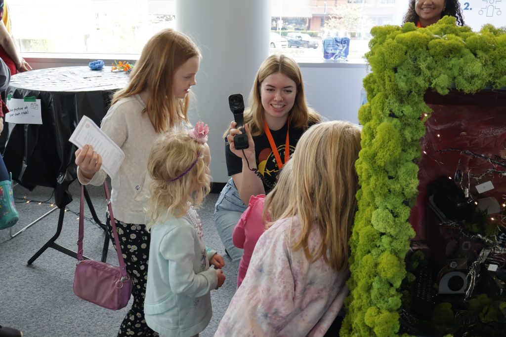 A woman shows a group of children a sculpture.